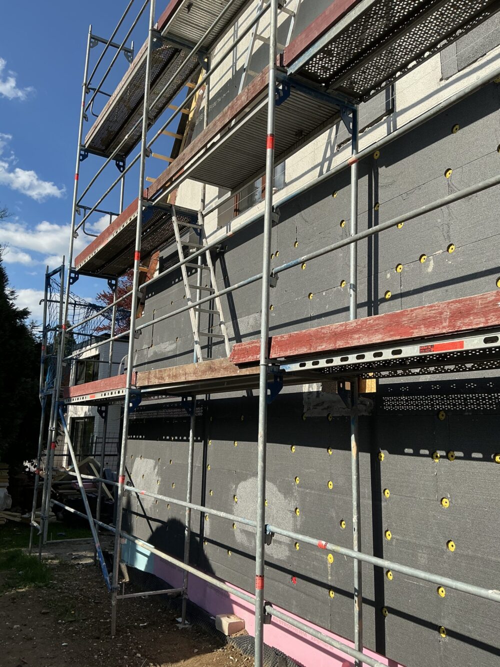 Baubegleitung bei Fassadendämmung an einem Wohngebäude mit Gerüst und kontrollierter Ausführung der Wärmedämmung