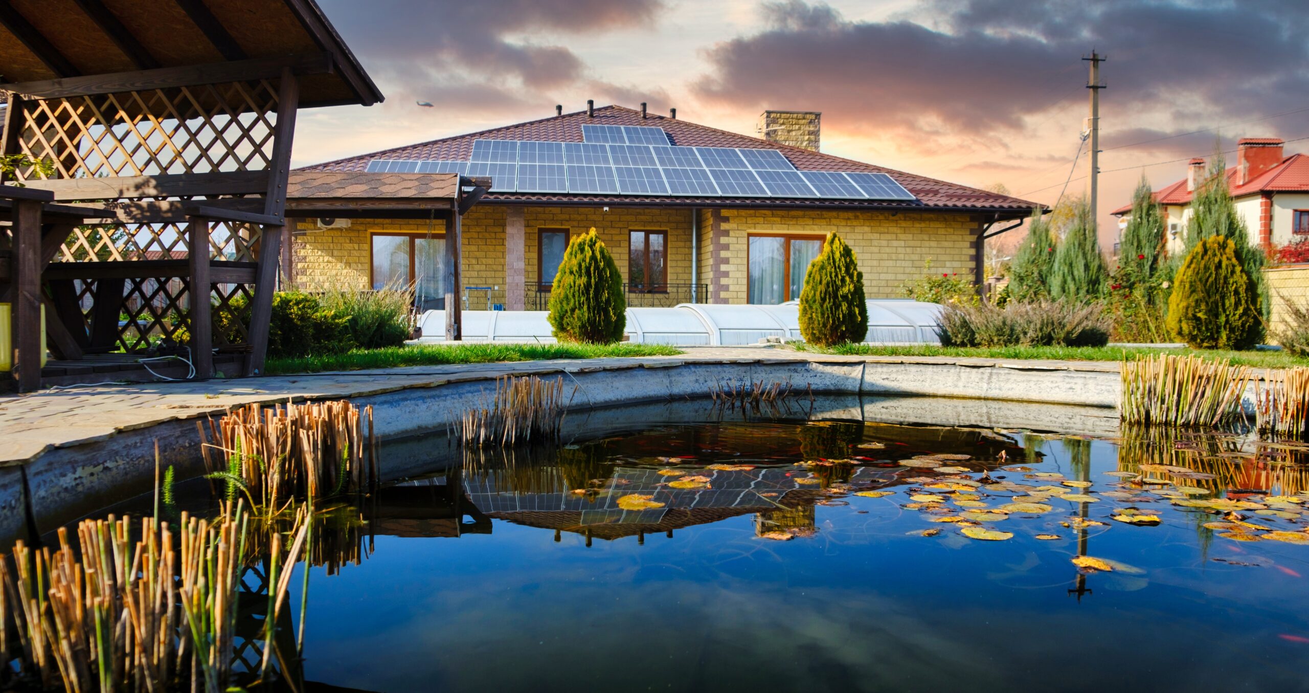 Klimafreundlicher Neubau (KFN) eines modernen Wohngebäudes mit Photovoltaikanlage und nachhaltigem Außenbereich.