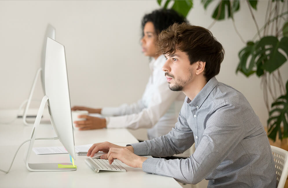 Zwei Bausachverständige von MJSV arbeiten fokussiert am PC an Gutachten und Energieberatungen im Büro.